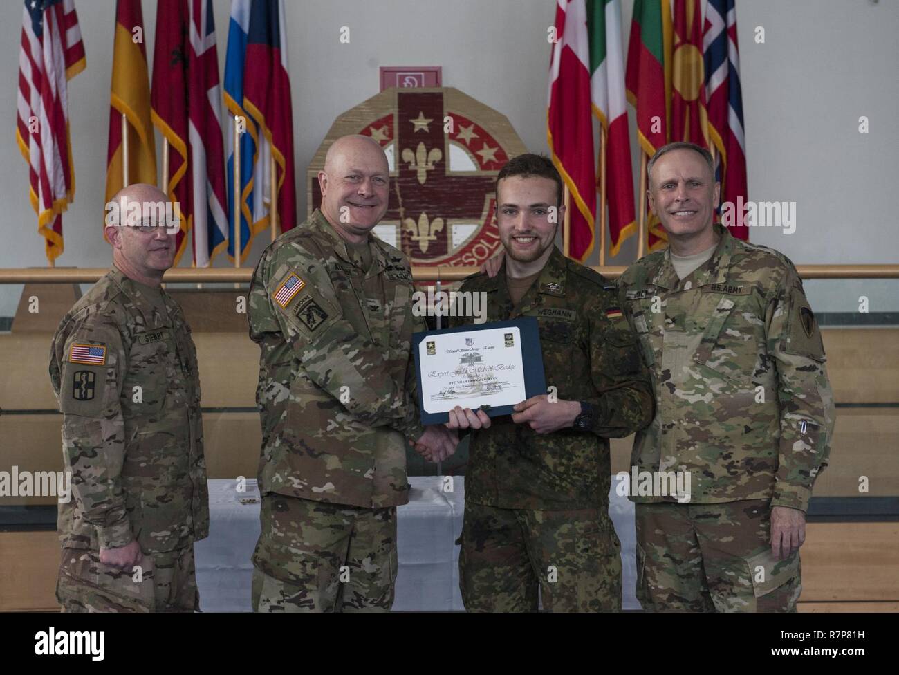 GRAFENWOEHR, Allemagne - Le Soldat de première classe Noé Leon Wegmann (centre droit), un expert médical de l'Armée américaine sur le terrain Badge (EFMB) destinataire avec l'armée allemande, reçoit un certificat d'achèvement de l'armée américaine le colonel Brian Almquist (centre gauche), commandant du 212e de l'Hôpital de soutien au combat, au cours d'une Europe de l'ARMÉE AMÉRICAINE EFMB Grafenwoehr en évaluation, en Allemagne le 30 mars 2017. Environ 215 candidats de l'armée américaine et européenne de dix pays partenaires ont participé à l'évaluation semestrielle dans l'espoir d'atteindre l'armée américaine convoitée EFMB mais seulement 64 l'ont reçu au cours de cette évaluation. Banque D'Images