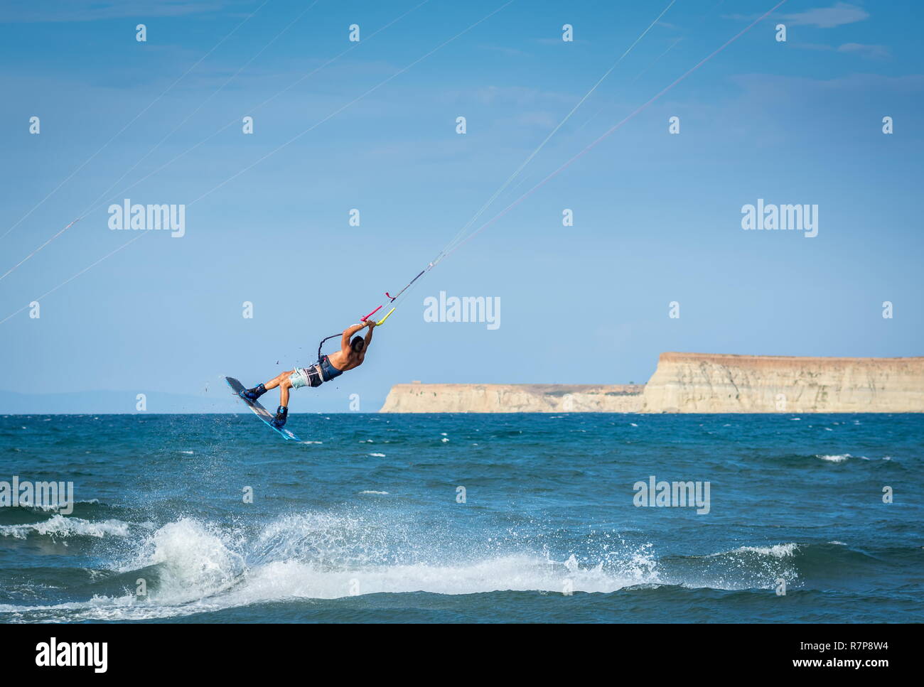 Athlète masculin kiteboarder kitesurfer kite faire tricks et sauts alors que le kitesurf Banque D'Images