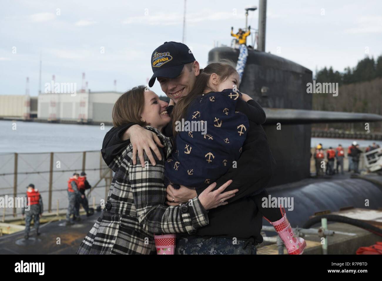 BANGOR, Washington (21 mars 2017) Directeur Logistique Kyle Bryant, spécialiste de Lowell, Massachusetts, attribué à l'équipage d'or de la classe Ohio-balistique sous-marin SNLE USS Nevada (733), embrasse sa famille comme le bateau retourne à base navale Kitsap-Bangor à la suite d'une patrouille de routine de dissuasion stratégique. Le Nevada est l'un des huit sous-marins des missiles balistiques stationnés à la base offrant le plus de chance de survie de la triade de dissuasion stratégique pour les États-Unis. Banque D'Images