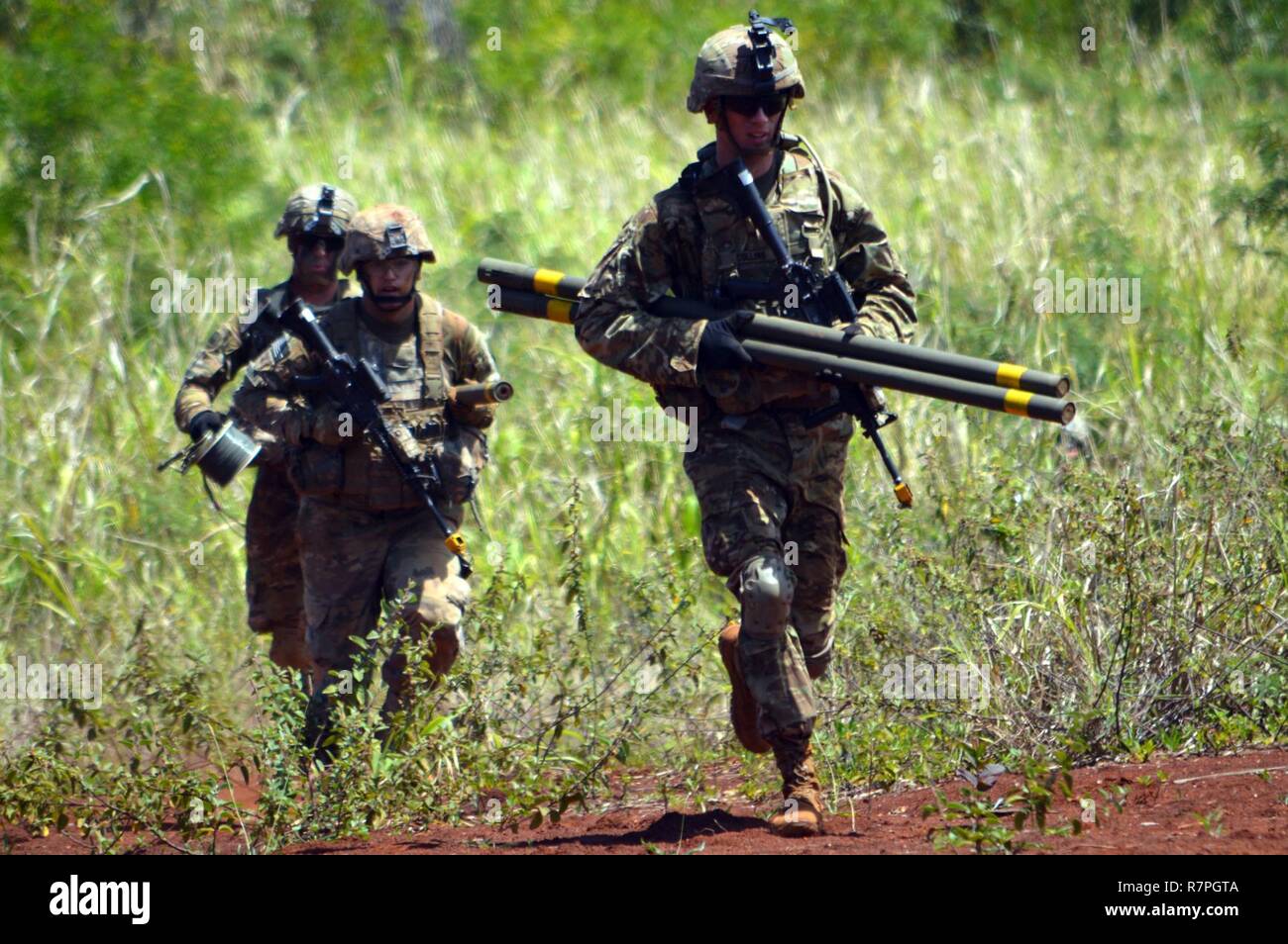 Les ingénieurs de combat affecté à la 29e brigade bataillon du génie, 3e Brigade Combat Team, 25e Division d'infanterie, transporter des torpilles Bangalore comme ils se précipitent à enfreindre un obstacle à Schofield Barracks, Missouri, le 25 mars 2017. Le but de la formation était d'éliminer un obstacle de fil afin que les soldats pouvaient traverser en toute sécurité. Banque D'Images