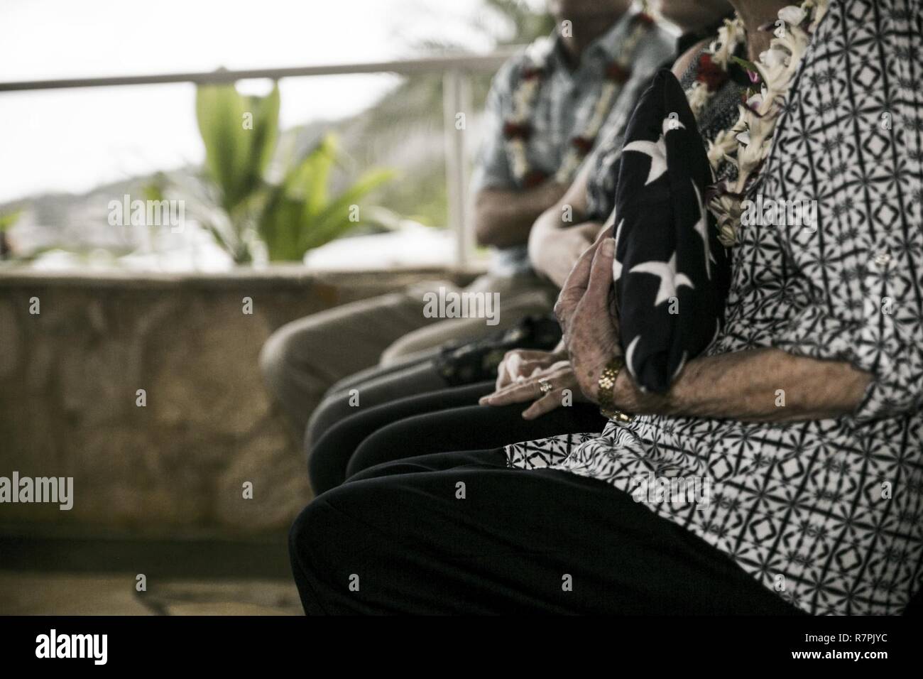 Debbie Hazelbaker, veuve de marin à la retraite, le Colonel Vincil W. Hazelbaker, tient le drapeau américain lors de son mari's memorial service au Hawaiian Memorial Park Cemetery le 24 mars 2017. Après la cérémonie, les hélicoptères de la Marine Aircraft Group 24 a effectué une formation de l'homme manquant, qui est un salut aérien effectué pendant un défilé aérien d'avions à un événement commémoratif, généralement à la mémoire d'un pilote tombé. Hazelbaker était un aviateur de Marine qui a servi dans l'armée depuis 34 ans. Au cours de son service, il a effectué plus de 680 missions de combat et a obtenu la Croix de la Marine pour son extraordinaire Banque D'Images