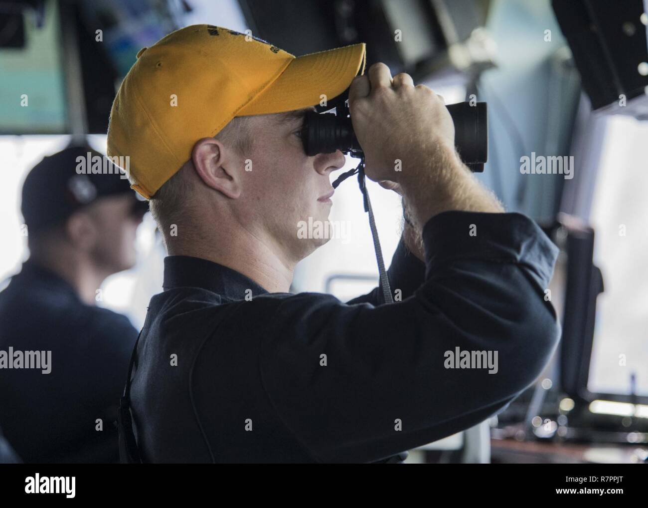 NDIAN OCÉAN (27 mars 2017) a appelé l'Ensign Foard, d'Annapolis, Md., numérise l'horizon alors que l'article général de la terrasse sur le pont du navire d'assaut amphibie USS Makin Island (DG 8). L'île de Makin, le navire amiral de l'île de Makin groupe amphibie, avec la 11e unité expéditionnaire de Marines embarqués, fonctionne en Indo-Asia-région du Pacifique pour améliorer capacité amphibie avec des partenaires régionaux et de servir de force de réaction-prêt pour tout type d'imprévus. Banque D'Images