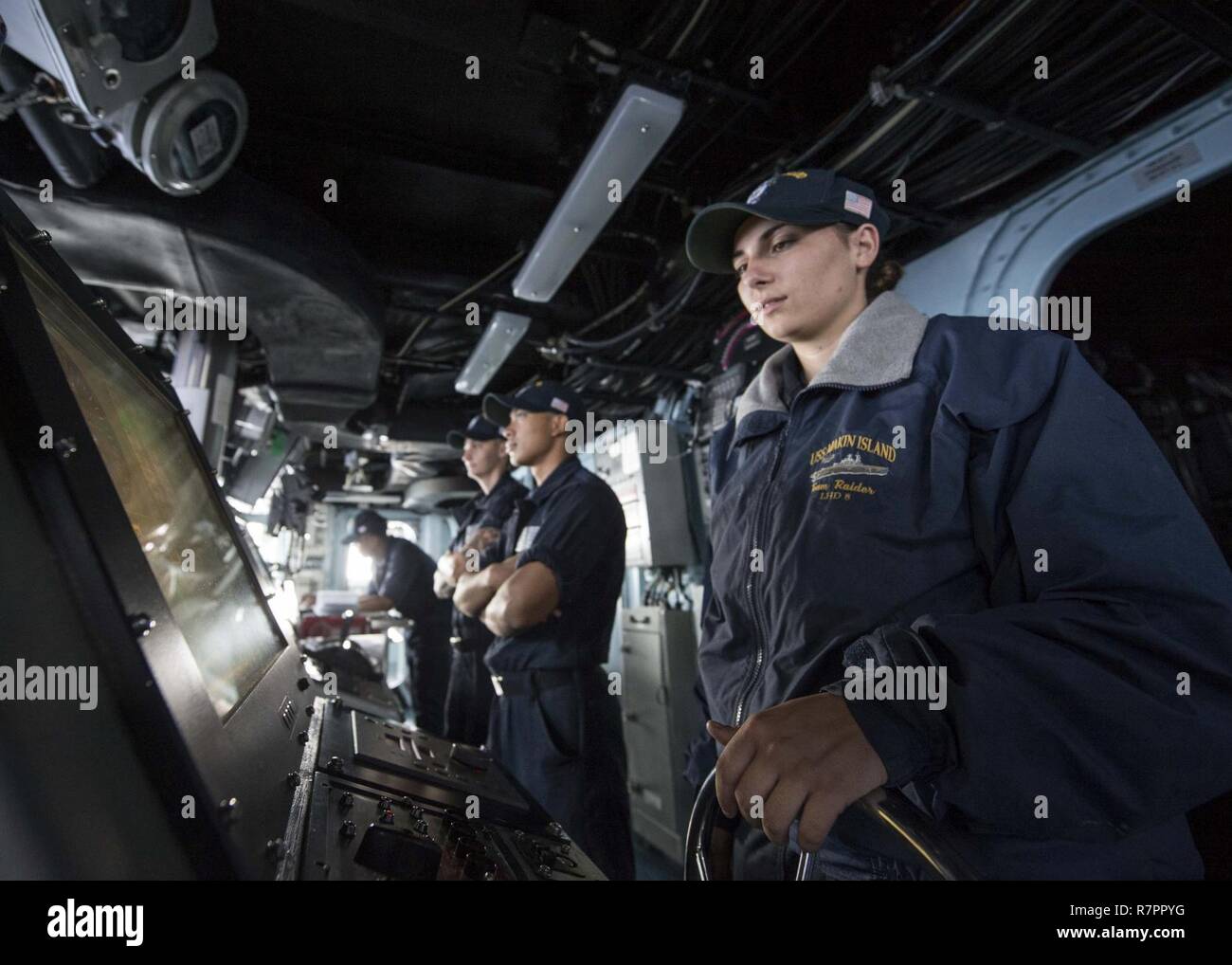 Océan Indien (27 mars 2017) Seaman Destany Schendel, droite, de Vicenza, Italie, les peuplements helm veille sur la passerelle du navire d'assaut amphibie USS Makin Island (DG 8). Le navire et son groupe amphibie, avec la 11e unité expéditionnaire de Marines embarqués, fonctionne en Indo-Asia-région du Pacifique pour améliorer capacité amphibie avec des partenaires régionaux et de servir de force de réaction-prêt pour tout type d'imprévus. Banque D'Images