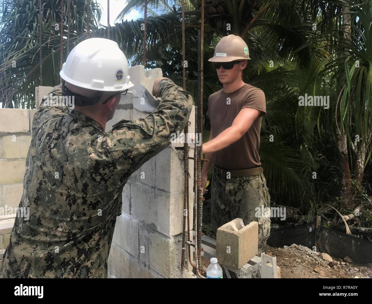 KOSRAE, Fédération de Micronésie (23 mars 2017) Builder Constructionman Lunders Skylar, droite, à partir de Fort Collins, Colorado, et le lieutenant Aaron Bell, un aumônier de la marine, des blocs d'unités de maçonnerie de béton tandis que la construction d'un mur extérieur de Walung Health Clinic à Kosrae, Fédération de Micronésie, le 23 mars 2017. Bataillon de construction Mobile naval (NMCB) 1 est la construction d'une nouvelle clinique de soins de santé dans le village de Walung à Kosrae. 1 NMCB est déployée avant d'exécuter la construction, l'aide humanitaire et l'aide étrangère, les opérations spéciales des services de soutien au combat, et le théâtre de la coopération en matière de sécurité dans supp Banque D'Images