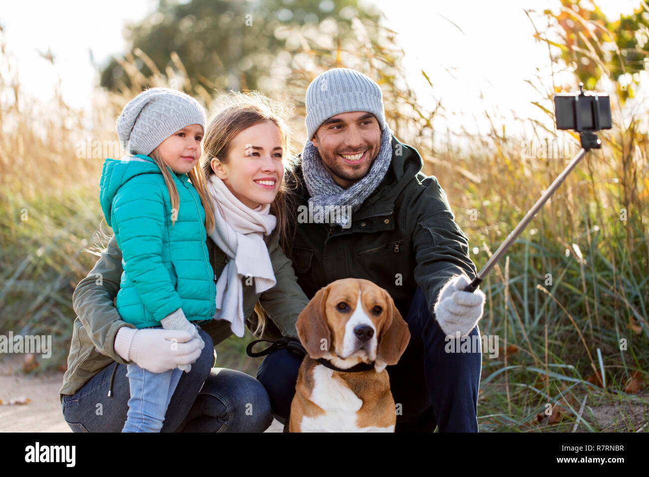 Famille heureuse avec chien prenant en automne selfies Banque D'Images