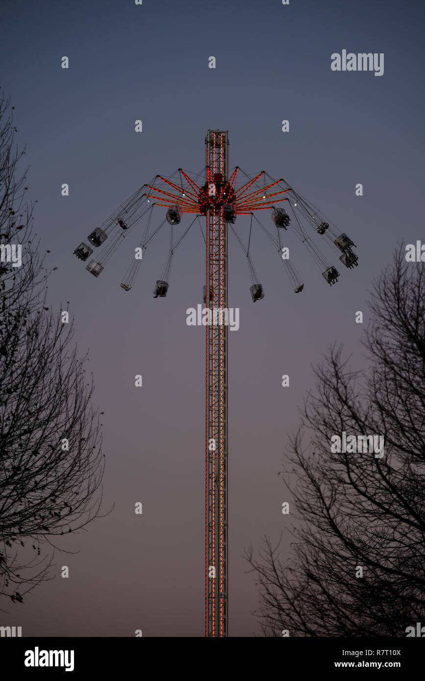 Dans le monde XXL sur le South Bank, Londres, au crépuscule avec des lumières. Parc d'ride avec des gens dans des chaises suspendues à bras rotatif Banque D'Images