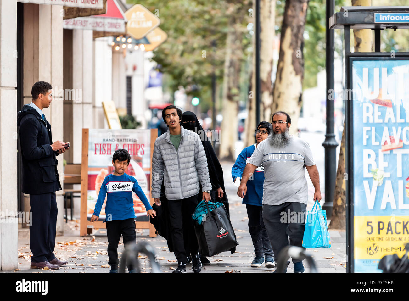 Londres, Royaume-Uni - 16 septembre 2018 : Les gens de la famille arabe musulmane marcher avec femme en hijab vêtements sur trottoir rue avec enfant à Kensington Banque D'Images