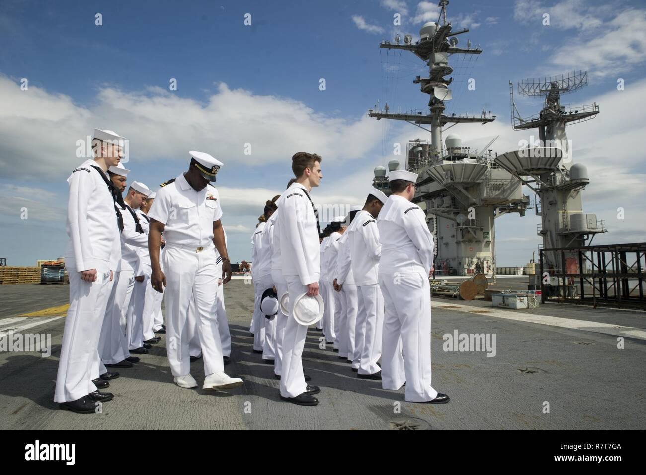 La NORFOLK (3 avril 2017) Le lieutenant J.G. Moh, Nnamdi centre, de l'Atlanta, inspecte les uniformes blancs robe des marins sur le pont du porte-avions USS George Washington (CVN 73). George Washington est homeported à Norfolk, en préparation de la mise à Newport News, en Virginie, pour l'avitaillement du navire révision complexe (RCOH) maintenance. Banque D'Images
