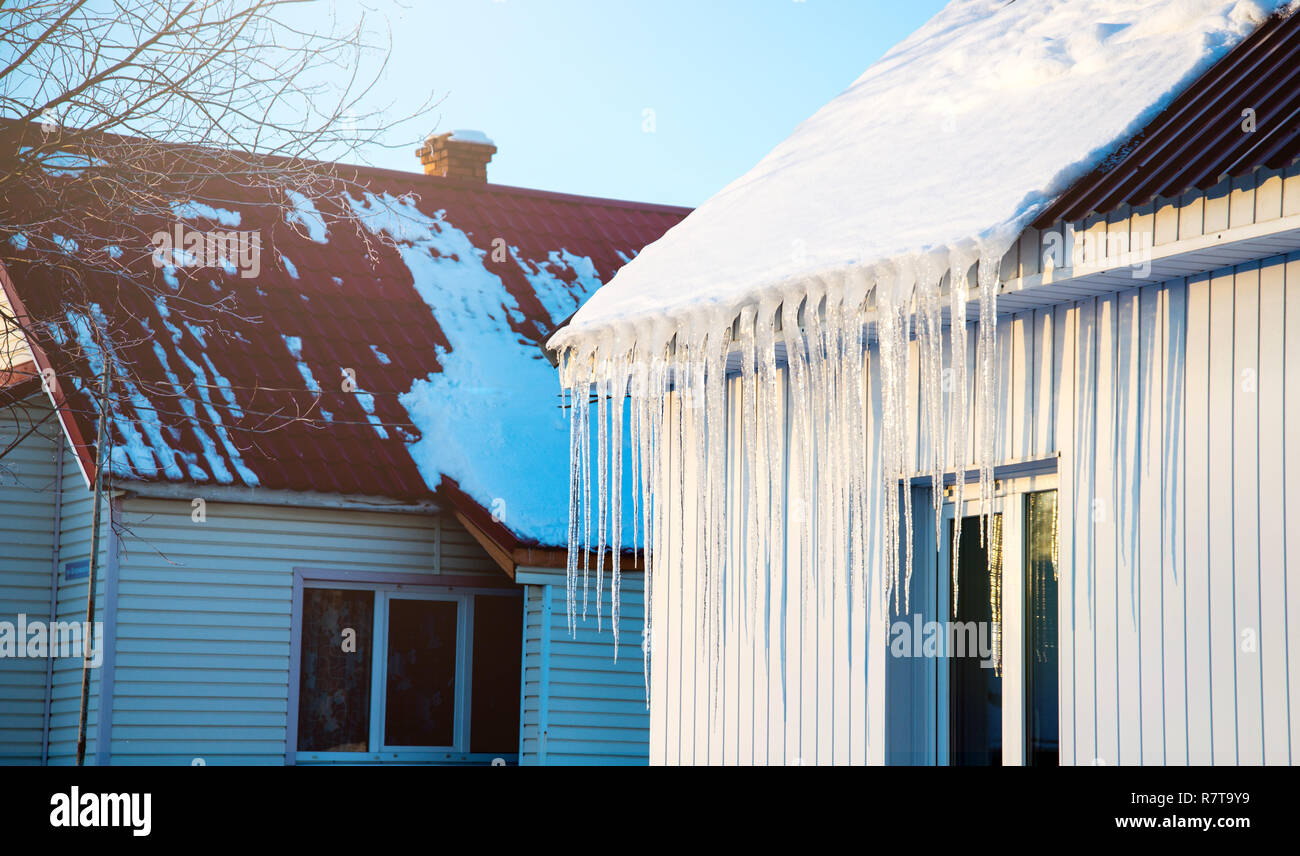 La petite maison avec des glaçons. La construction résidentielle sur une journée d'hiver, un peu de neige sur le toit au soleil, horizontal tourné Banque D'Images