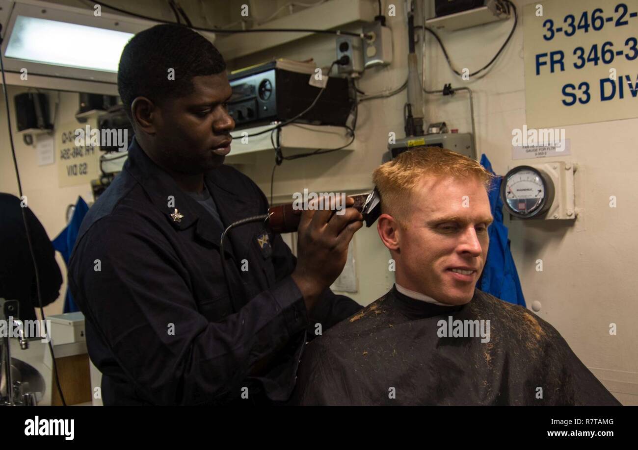 L'OCÉAN ATLANTIQUE (Mar. 31, 2017) Le Cmdr. Stephen W. Aldridge, commandant de l'USS destroyer lance-missiles Mason (DDG 87), reçoit une coupe provenant des navires militaires 1ère classe Quintin Ellis. Mason, une partie de l'Eisenhower, le Groupe est en cours participant à un exercice de soutien en faveur de l'optimisation du Plan d'intervention de la flotte (OFRP). Banque D'Images