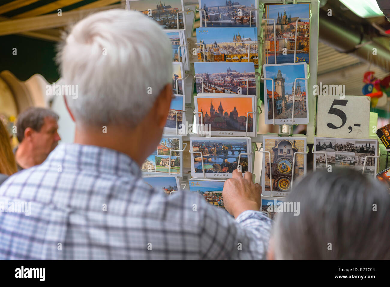 Prague, vue arrière d'un touriste dans le marché à Prague Havelske parcourt les cartes postales montrant des images iconiques de la ville, République tchèque. Banque D'Images