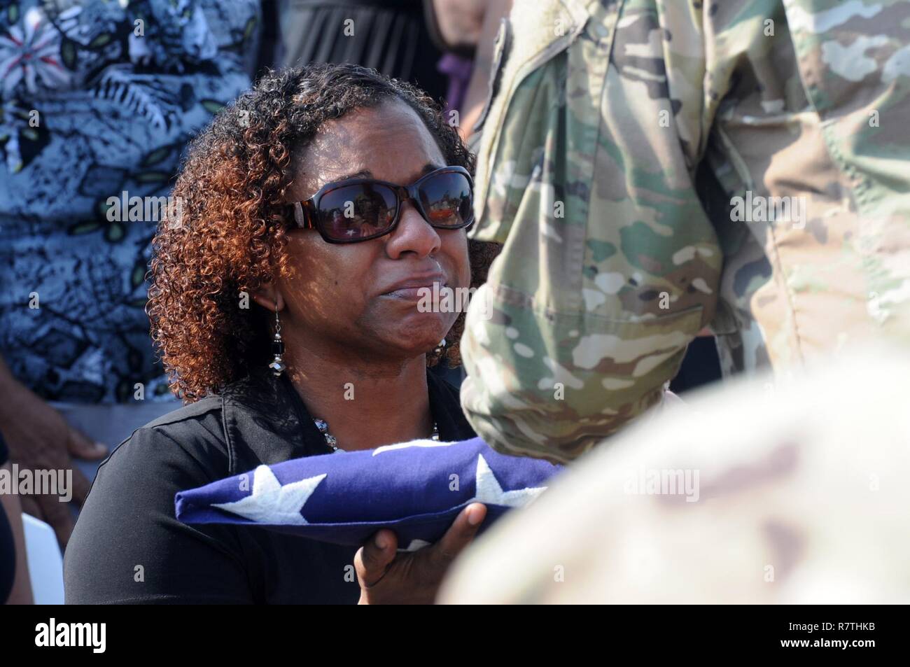 Deshana Pandy reçoit un drapeau américain à partir de la commande le Sgt. Grand Angel Rivera dans un salon funéraire détail pour son père, 22 ans, vétéran de l'Armée Le sergent-chef. David Daniel Alexander Pandy Jr., à un cimetière à Ladyville Belize, le 30 mars 2017. Le sergent-major est un réserviste de Puerto Rico du 210e groupe d'appui régional affecté à au-delà de l'horizon 2017-BELIZE, Belize un exercice de partenariat englobant trois événements de santé et cinq projets de construction visant à améliorer l'infrastructure de santé et d'éducation des communautés bélizienne. Banque D'Images