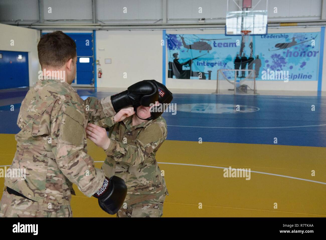 Le sergent de l'armée américaine. Bryan Sandino, assistant instructeur, avec les Forces alliées du Nord de l'Europe (AFNORTH) Battalion, poinçons Pvt. Madeline Olson, affectés à l'établissement de santé de forme, comme elle tente de décrocher lui afin d'arrêter son poing, pour une classe de niveau un combatives enseigné sur la base aérienne de Chièvres, Belgique, le 22 mars 2017. Bataillon d'AFNORTH, USANATO led Brigade cette classe ouverte aux forces militaires stationnées dans le Benelux. Banque D'Images