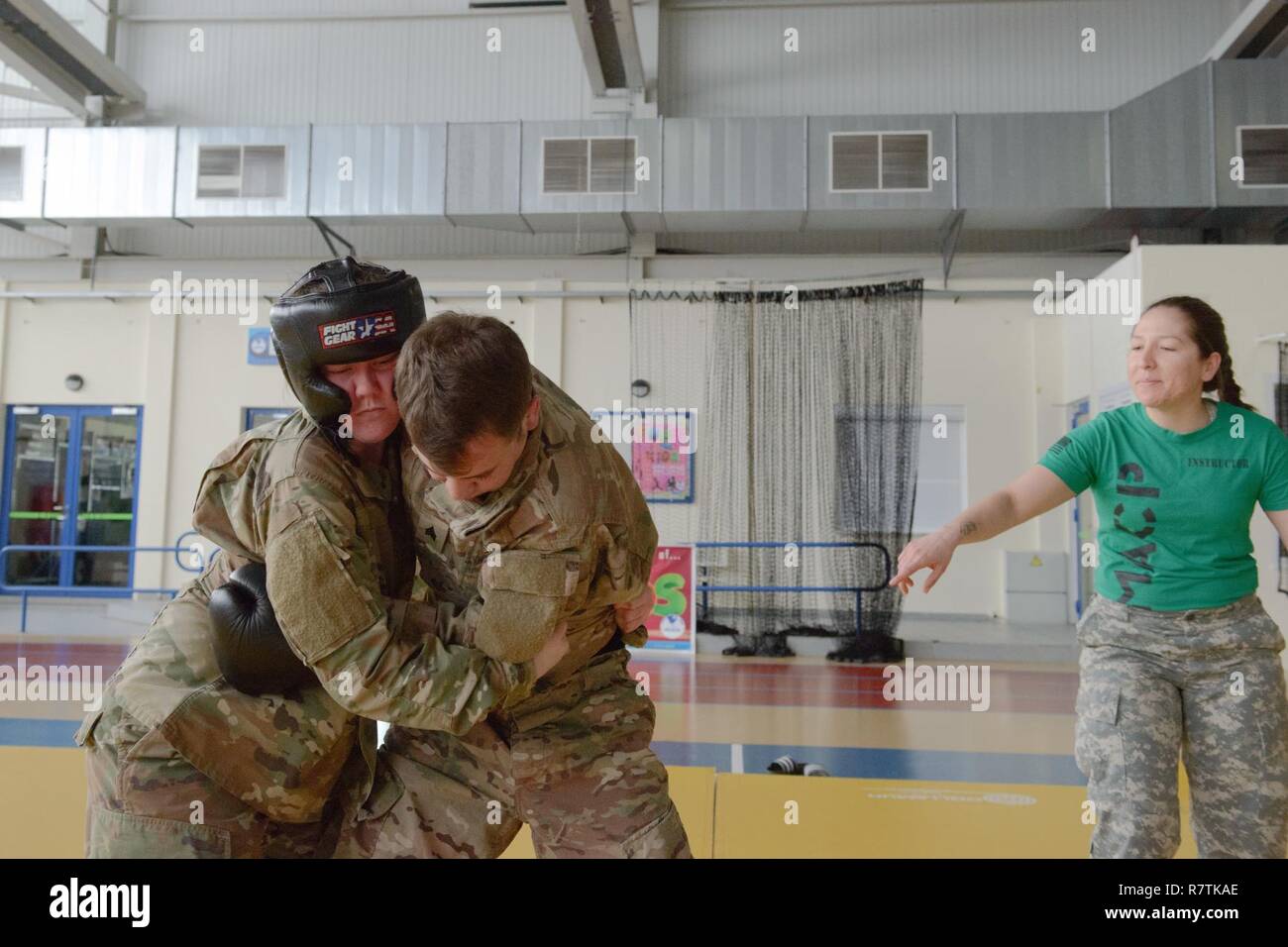 Le sergent de l'armée américaine. Maria Acuna, droite, instructeur principal, vérifie si Pvt. Madeline Olson, affectés à l'établissement de santé forme effectue un bon accrochage sur le Sgt. Bryan Sandino, assistant instructeur, afin d'arrêter son poing, pour une classe de niveau un combatives enseigné sur la base aérienne de Chièvres, Belgique, le 22 mars 2017. Acuna et Sandino sont tous deux avec USANATO AFNORTH bataillon, brigade, l'unité qui a conduit cette classe ouverte aux forces militaires stationnées dans le Benelux. Banque D'Images