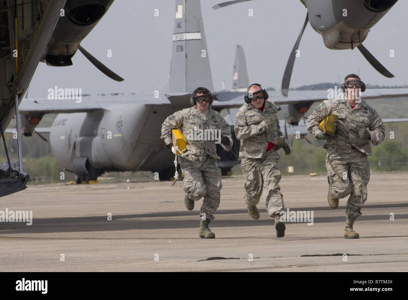 (De gauche à droite) U.S. Air Force Reserve Tech Sgt. Danny Canup, Tech Sgt. Jason Gibson et Master Sgt. Morgan Abner ruée pour la ligne d'arrivée pour arrêter le réveil, après le déchargement d'un C-130J Super Hercules Le 2 avril 2017, à la base aérienne de Little Rock, Ark. Les aviateurs, sont affectés à la 96e Escadron Port Aérien, pratiquaient pour le Port 2017 Dawg Défi pour être tenue à Dobbins Air Reserve Base, Ga. Banque D'Images