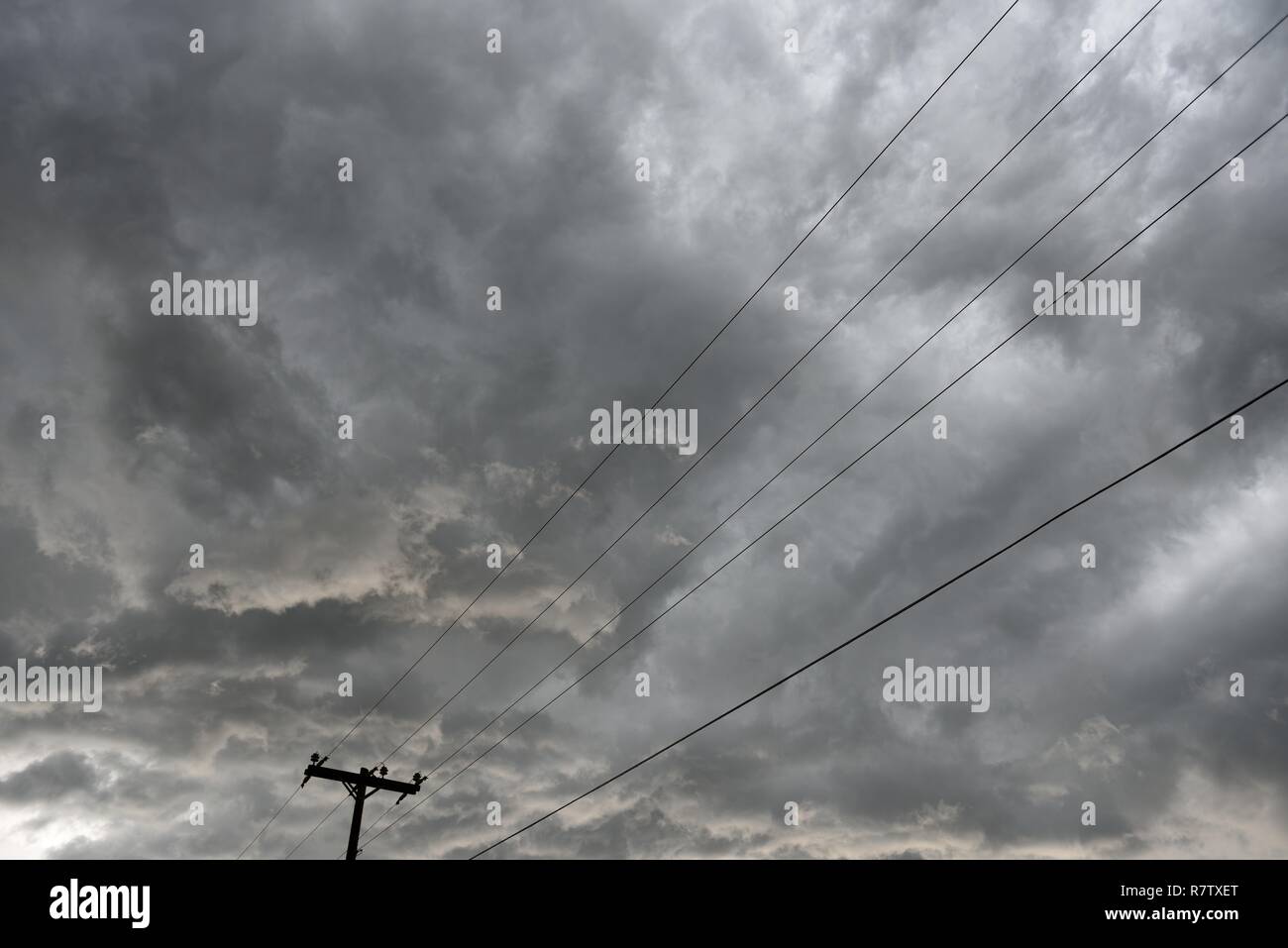 Poteaux et lignes électriques, infrastructure de distribution d'électricité avec nuages et ciel orageux au Wyoming, aux États-Unis Banque D'Images