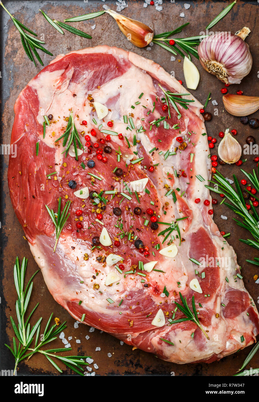 La viande fraîche. Épaule d'agneau cru prêt pour la cuisson avec l'ail, le romarin, le genévrier, poivre et sel. La cuisson d'un délicieux dîner. Selective focus Banque D'Images