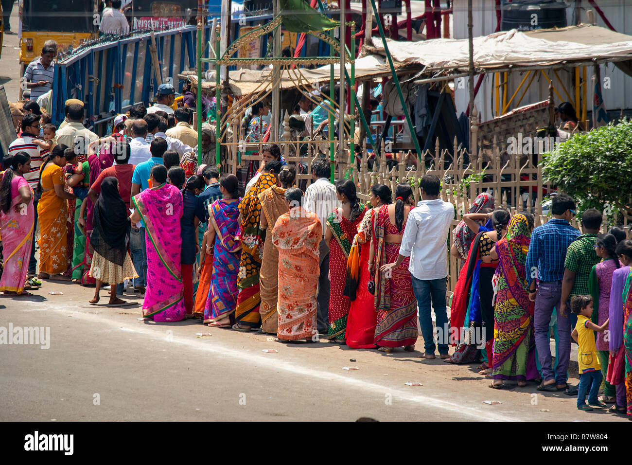 Une ligne lumineuse et colorée des femmes indiennes vêtues de leur sari traditionnel de mise en file d'un inconnu pour l'occasion. Banque D'Images