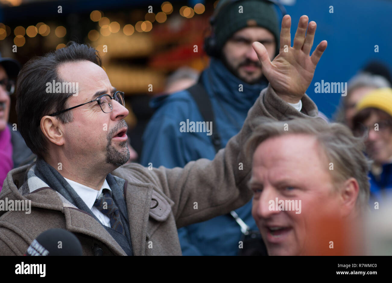 Symbole - 11 décembre 2018, en Rhénanie du Nord-Westphalie, Münster : les acteurs Jan Josef Liefers (l) dans le rôle de M. Karl-Friedrich Boerne et Axel Prahl comme le commissaire Frank Thiel chanter ensemble au Marché de Noël à une séance photo pour la nouvelle scène de crime (ARD) "ann steht der Mörder vor der Tür". Photo : Friso Gentsch/dpa Banque D'Images