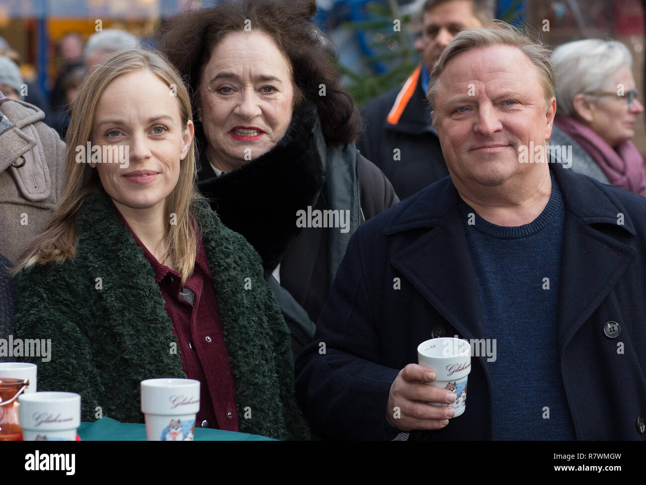 Symbole - 11 décembre 2018, en Rhénanie du Nord-Westphalie, Münster : les acteurs Friederike Kempter (l-r) comme Krustenstern Nadeshda, Mechthild Grossmann comme Wilhelmine Klemm et Axel Prahl comme le commissaire Frank Thiel se tenir ensemble au marché de Noël à une séance photo pour la nouvelle scène de crime WDR 'Dann steht der Mörder vor der Tür". Photo : Friso Gentsch/dpa Banque D'Images