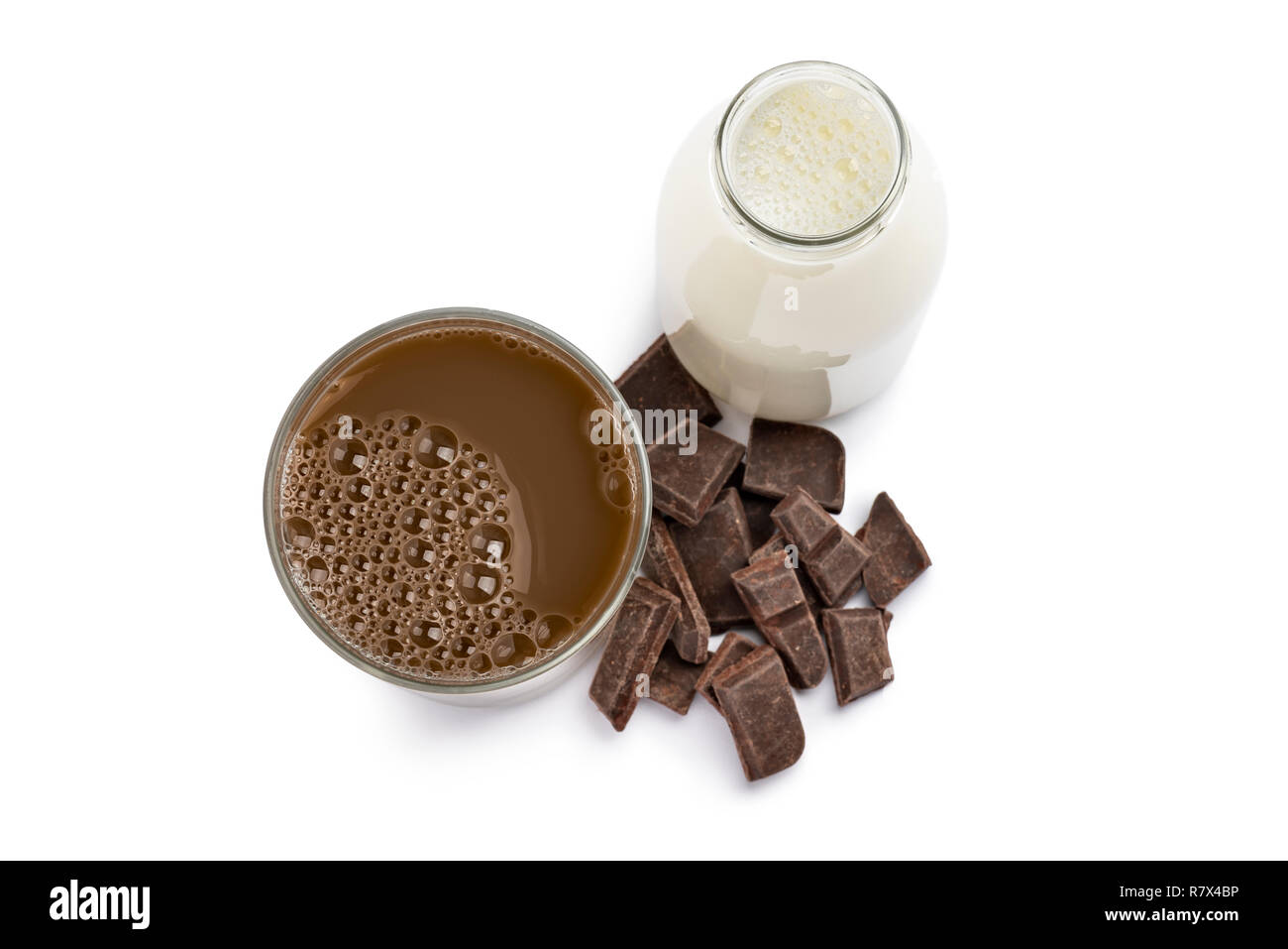 Verre et bouteille de lait au chocolat avec des blocs de chocolat sur fond blanc Banque D'Images