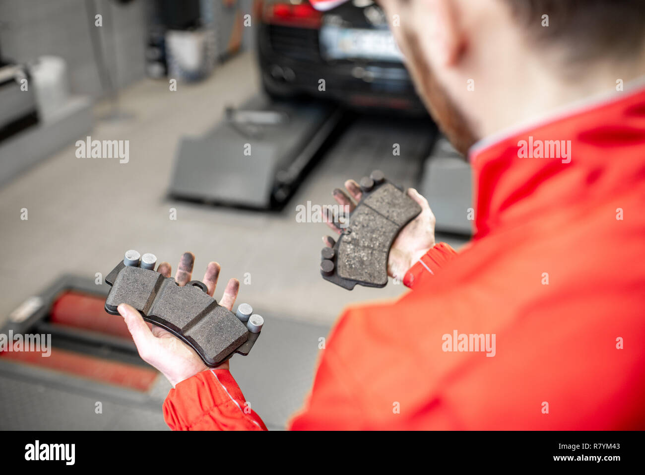 Auto mechanic holding nouveau et utilisé la voiture au niveau des plaquettes de frein, close-up view Banque D'Images