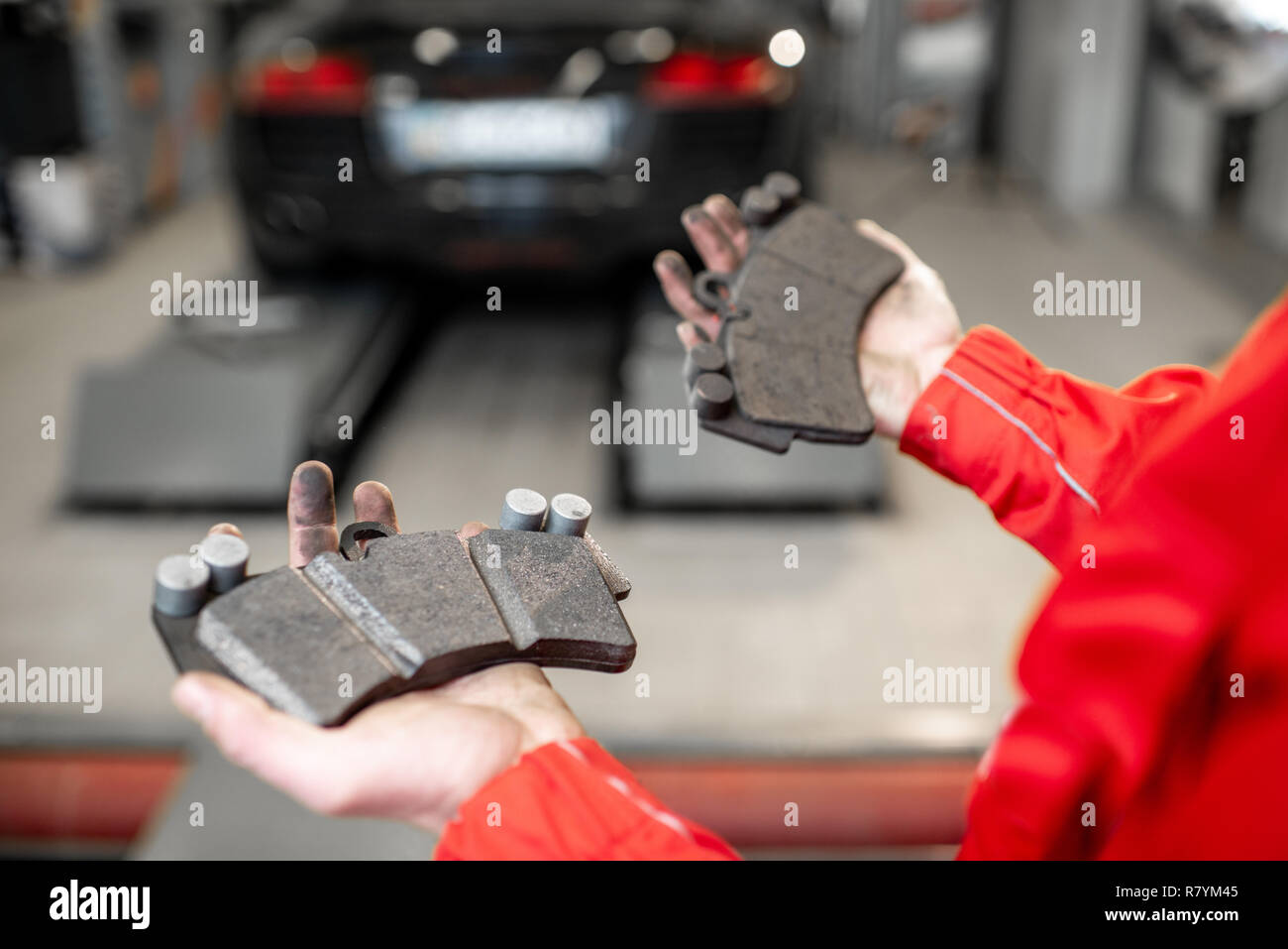 Auto mechanic holding nouveau et utilisé la voiture au niveau des plaquettes de frein, close-up view Banque D'Images