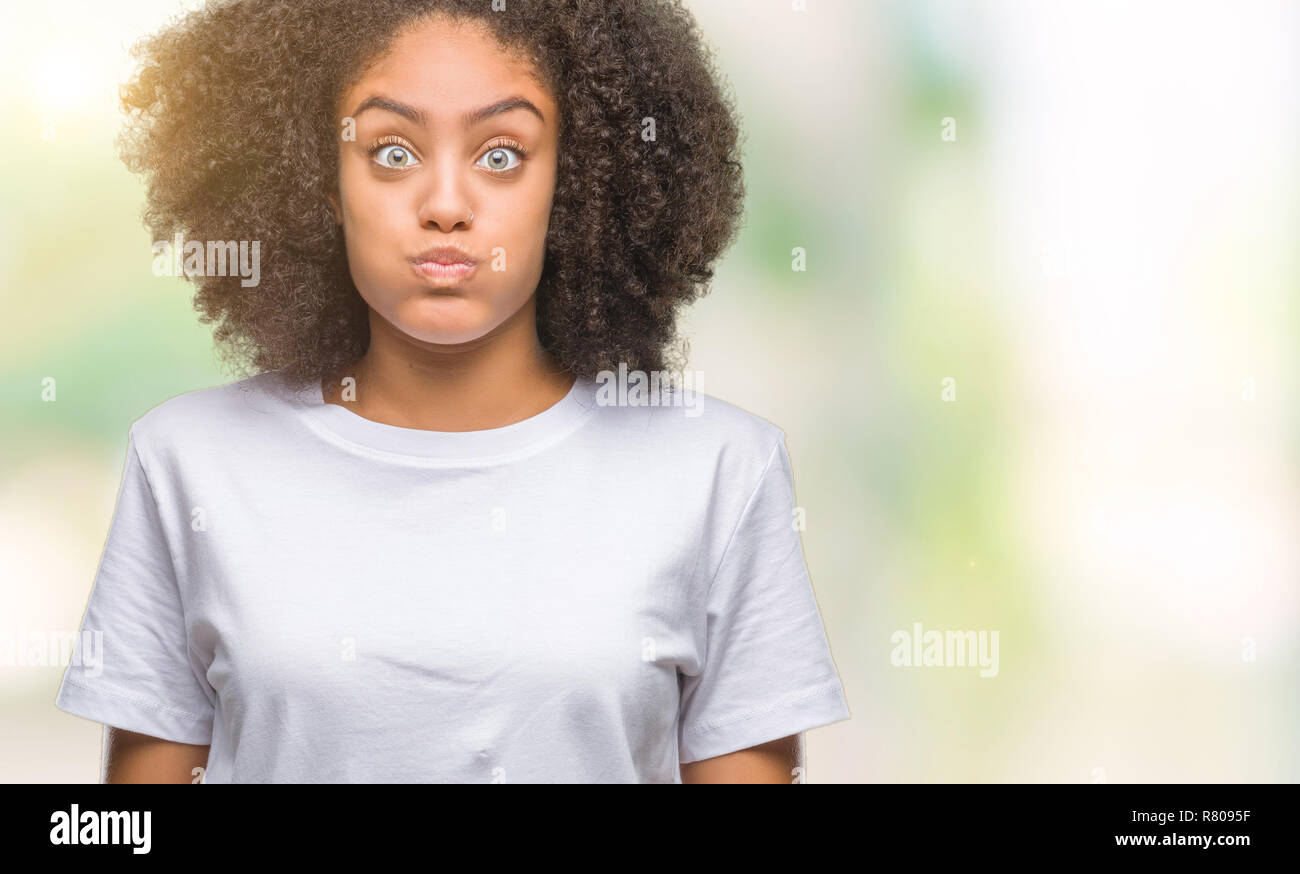 Femme plus jeune fond isolé que quelques bouffées joues avec drôle de visage. Bouche gonflé à l'air, l'expression fou. Banque D'Images