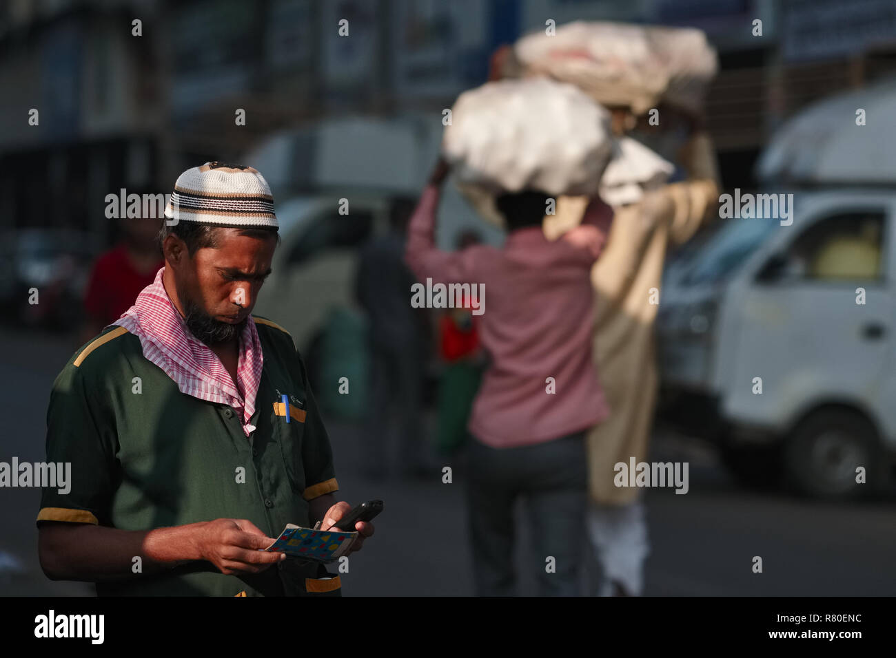 Un homme à Mumbai, Inde, occupé à essayer d'obtenir sa nouvelle carte SIM pour travailler, le prestataire de services d'entretien dans la main Banque D'Images