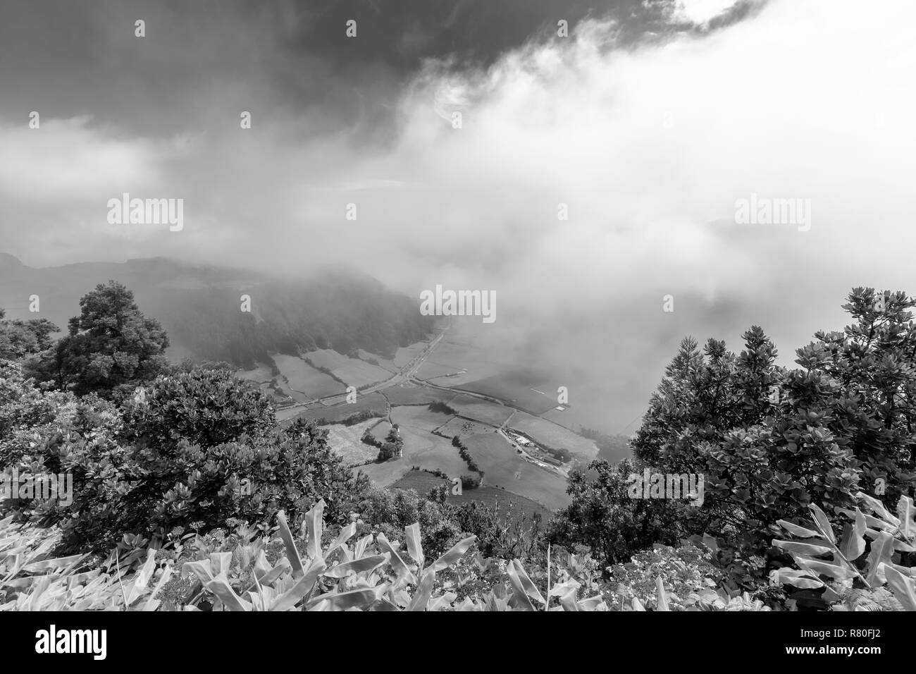 Vue en noir et blanc des nuages et les pâturages dans la caldeira de Sete Cidades à Sao Miguel, Açores. Banque D'Images