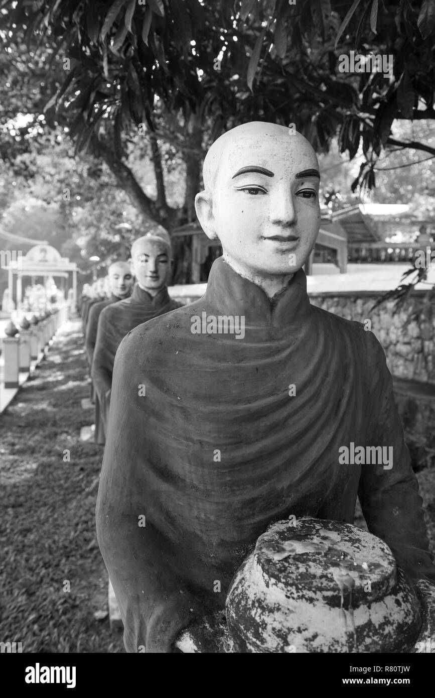 Photo noir et blanc de moines statues, symbole de l'offrant au Kaw Ka Thaung Cave, situé à proximité de Hpa-An, Myanmar Banque D'Images