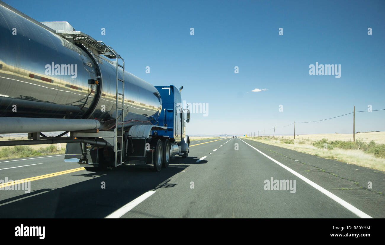 Camion avec une remorque réservoir d'argent passant une voiture sur une route Banque D'Images