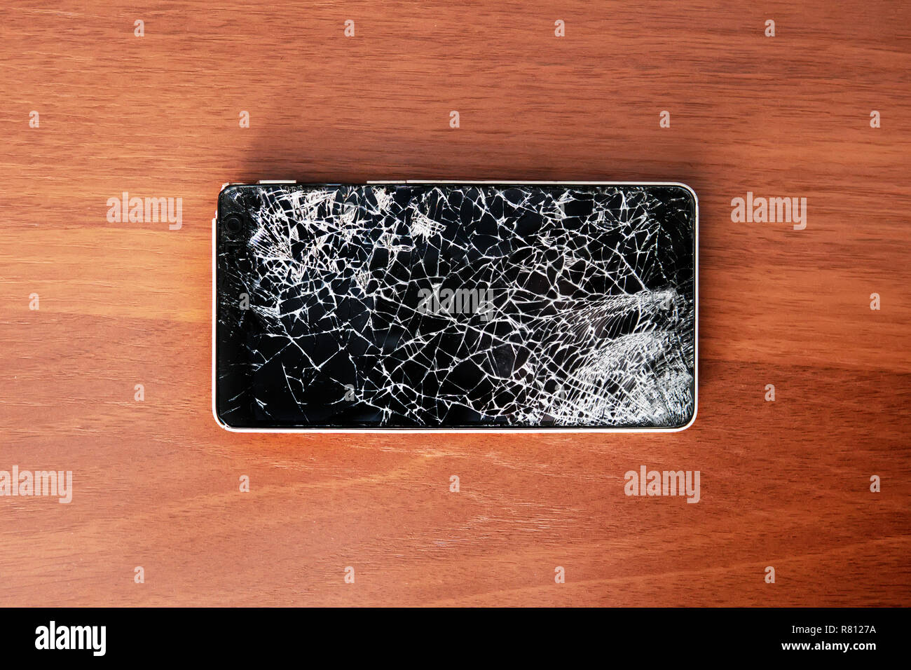 Smartphone avec écran cassé sur la table en bois Banque D'Images