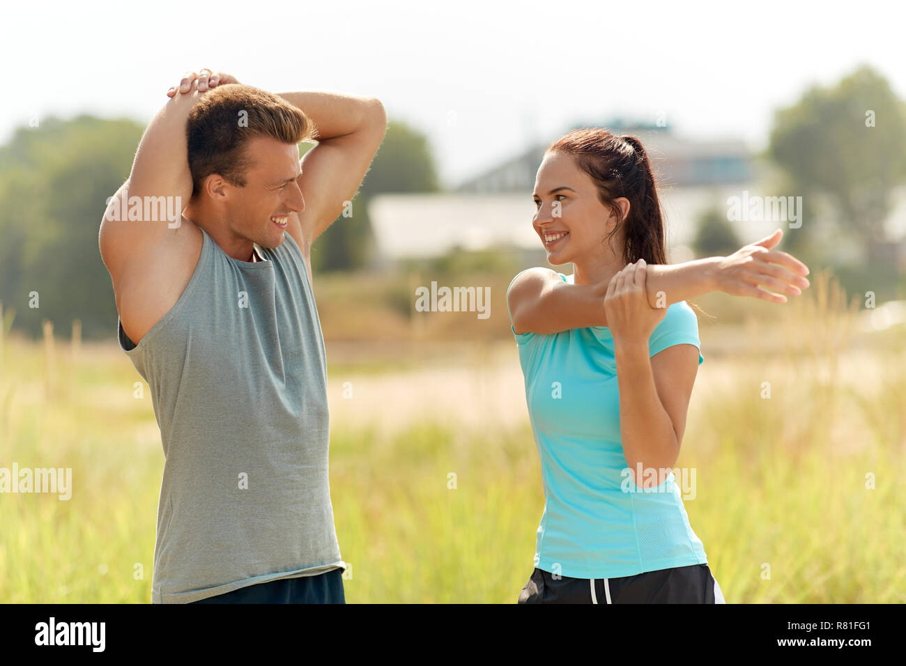 Smiling couple stretching outdoors Banque D'Images