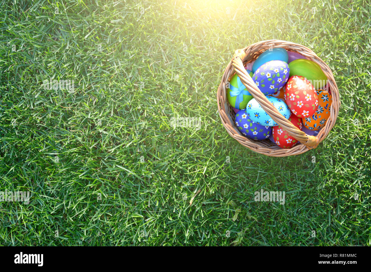 Télévision jeter coup d'œufs de Pâques dans le panier en osier sur green spring grass Banque D'Images