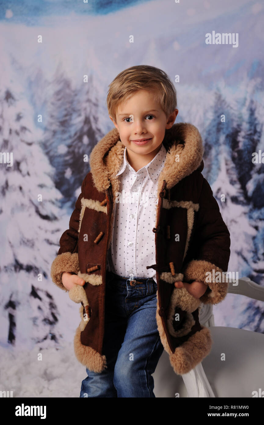 L'enfant d'hiver session. Un garçon dans un manteau en peau de mouton et un  foulard, en hiver Photo Stock - Alamy