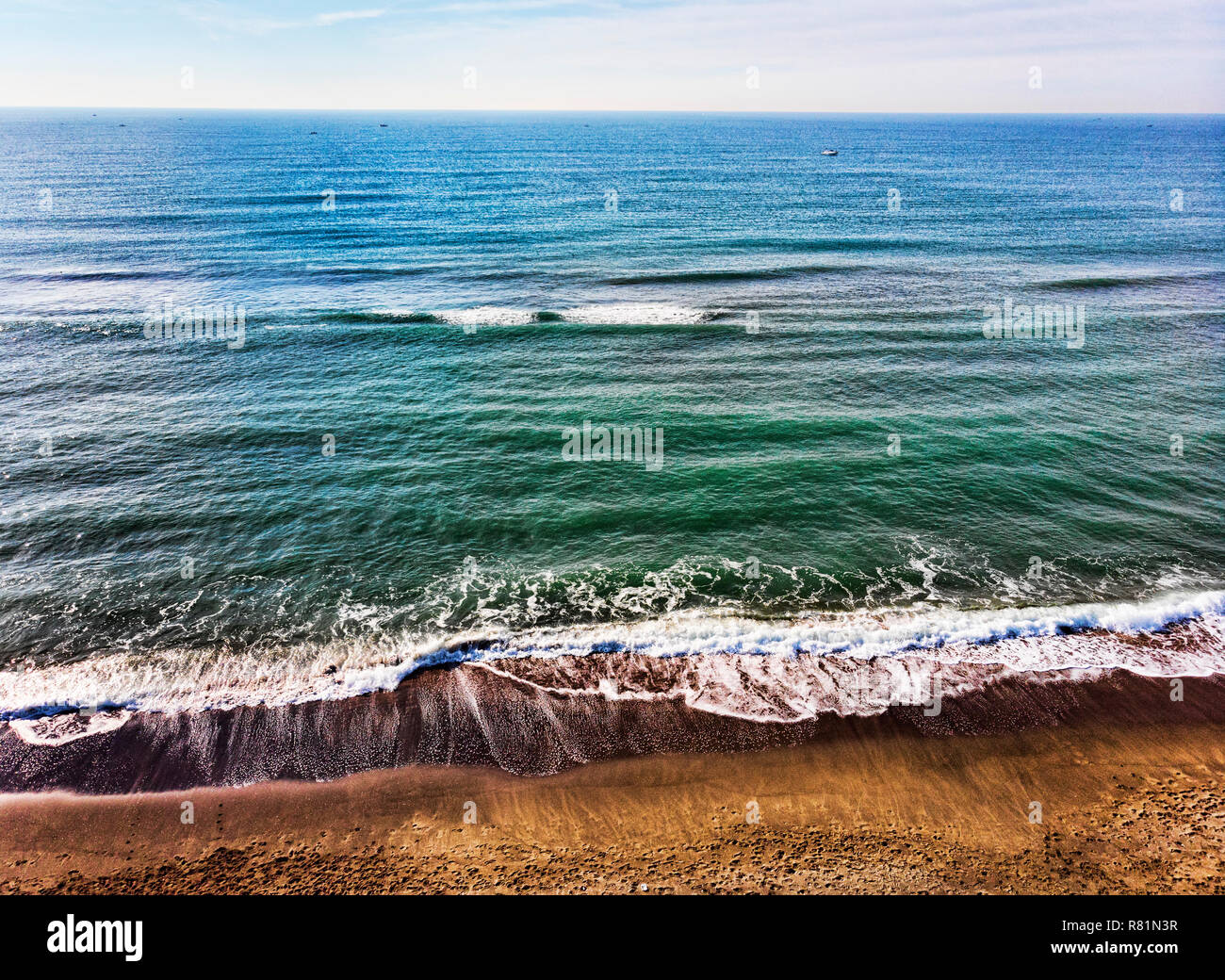 Vue aérienne de la plage et d'un océan bleu et calme avec de nombreux bateaux dans la distance Banque D'Images