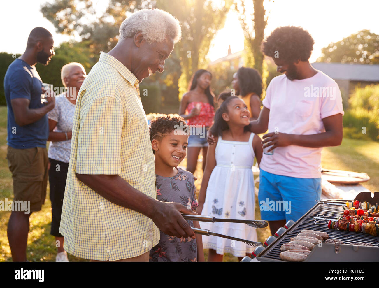 Grand-père et petit-fils lors d'une cuisson barbecue familial Banque D'Images