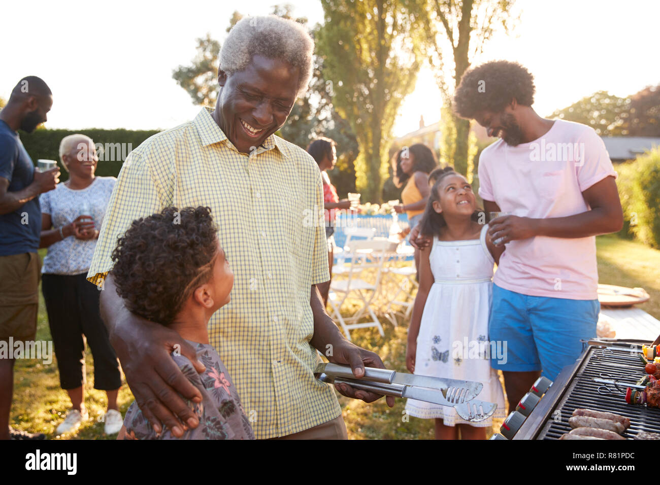 Papi et papa parler avec les enfants à un barbecue familial Banque D'Images