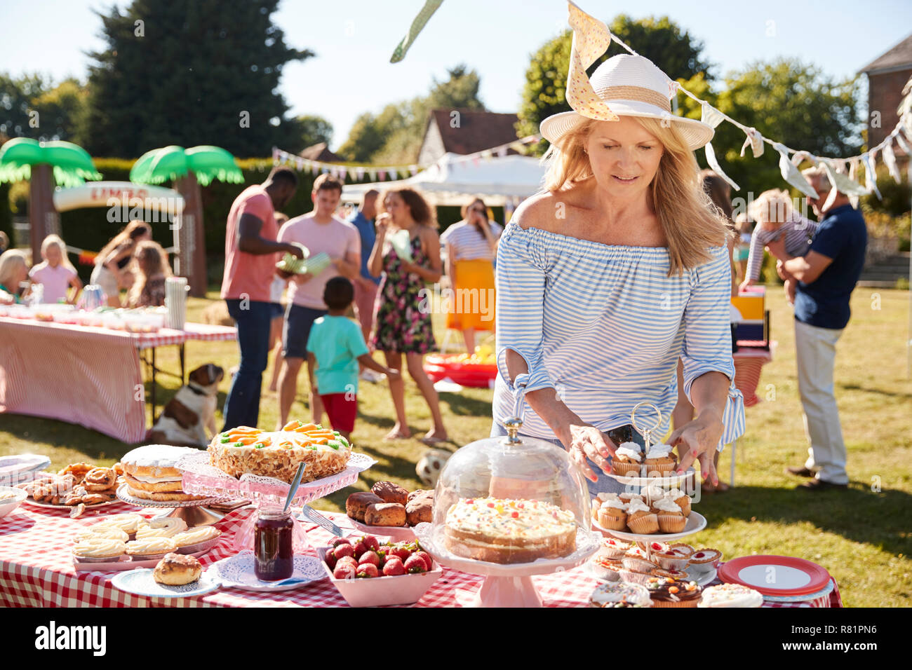 Femme mature servant On Cake stand à été occupé Jardin Fete Banque D'Images Femme mature servant On Cake stand à été occupé Jardin Fete Banque D'Images