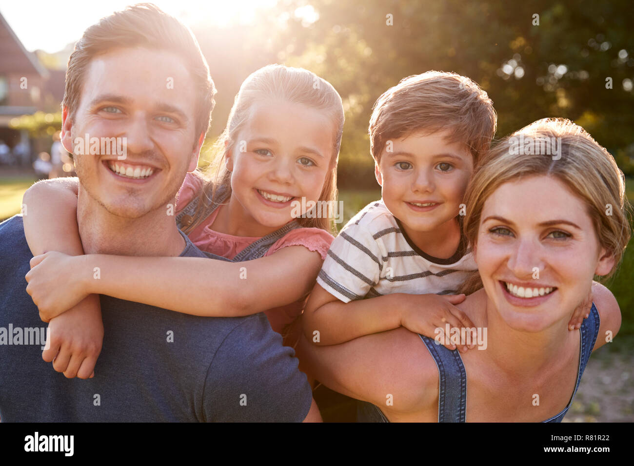 Portrait Of Smiling Family l'extérieur en été Park contre Sun Torchage Banque D'Images