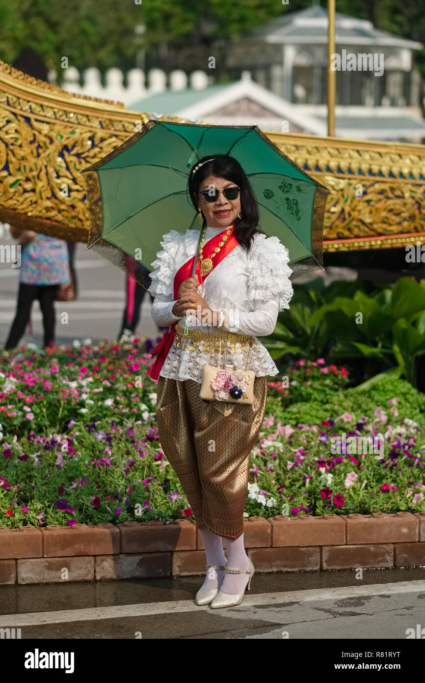 Au cours d'un événement commémoratif pour le défunt Roi Bhumipol Adulyadej thaïlandais à Bangkok, Thaïlande, une femme pose en robe traditionnelle thaïlandaise Banque D'Images