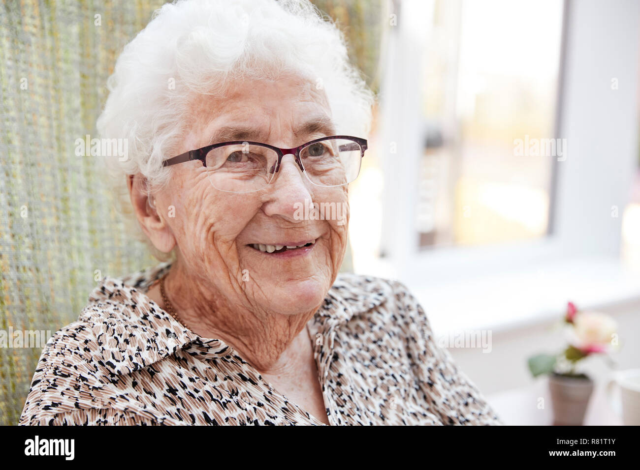 Portrait of Senior Woman Sitting in Chair dans le salon d'une maison de retraite Banque D'Images