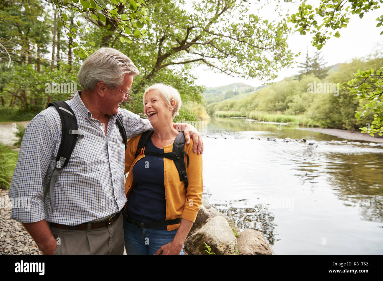 Couple de la randonnée le long de la rivière par le chemin au Royaume-Uni Lake District Banque D'Images