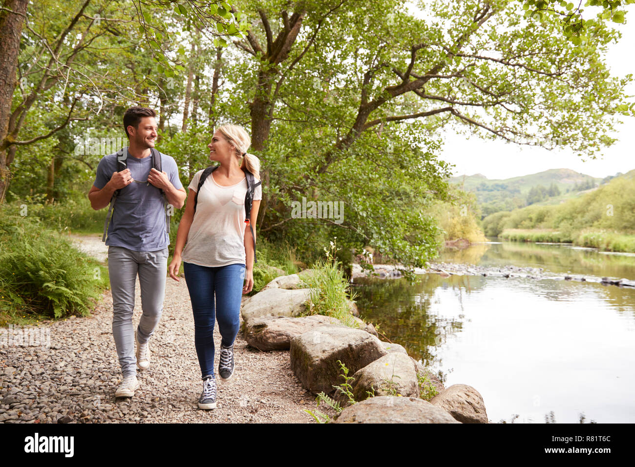 Couple de la randonnée le long de la rivière par le chemin au Royaume-Uni Lake District Banque D'Images