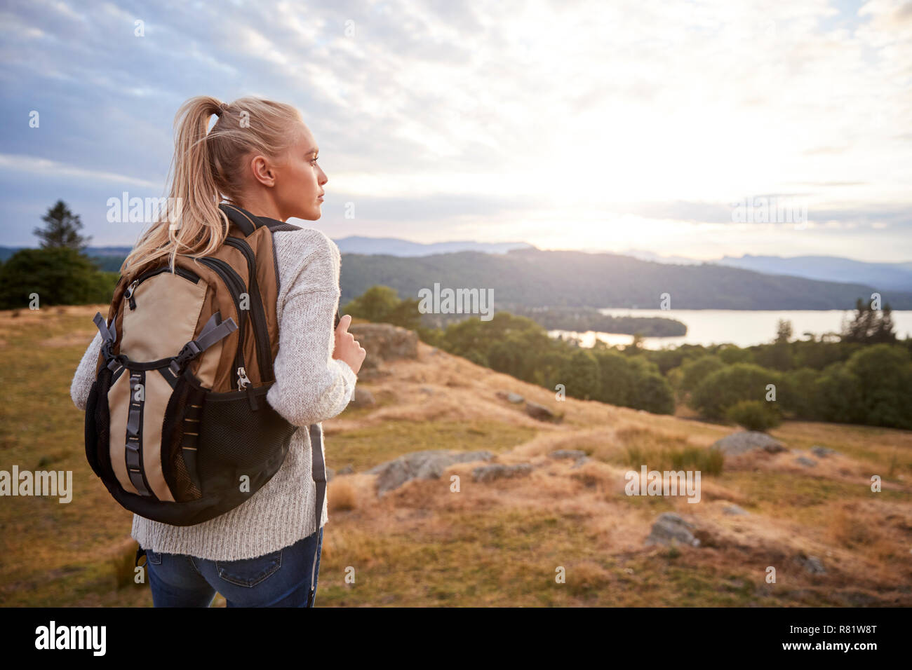 Un jeune adulte Caucasian woman Standing alone on the hill au cours de randonnées, admiring view, vue arrière Banque D'Images