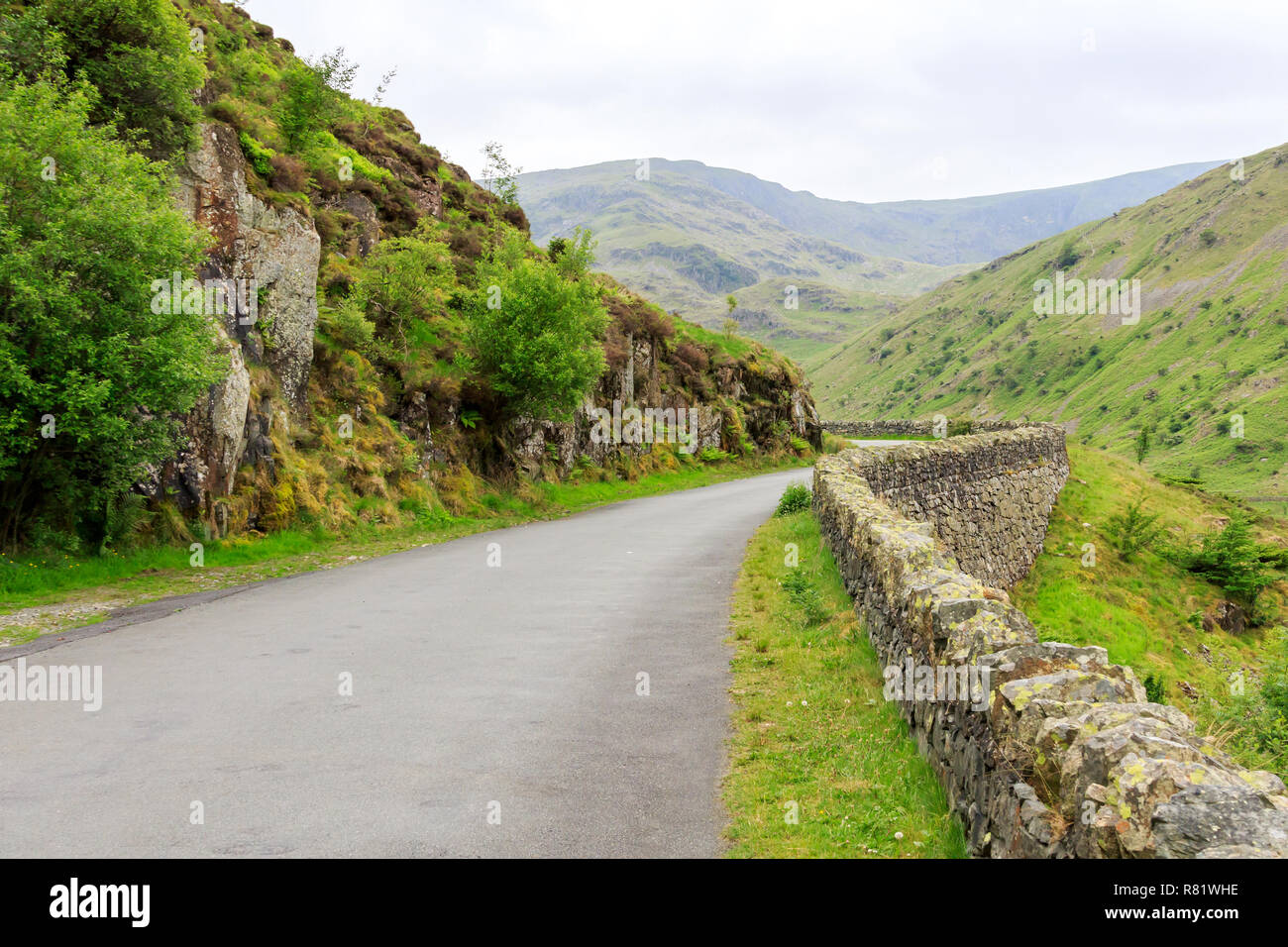 Une route bordée d'un mur de pierre dans le collines de Cumbrie Banque D'Images