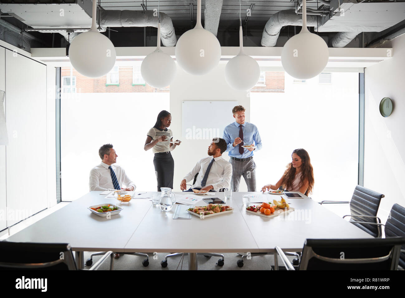 Hommes et de femmes d'affaires et salle de réunion moderne en plus de déjeuner de travail Banque D'Images