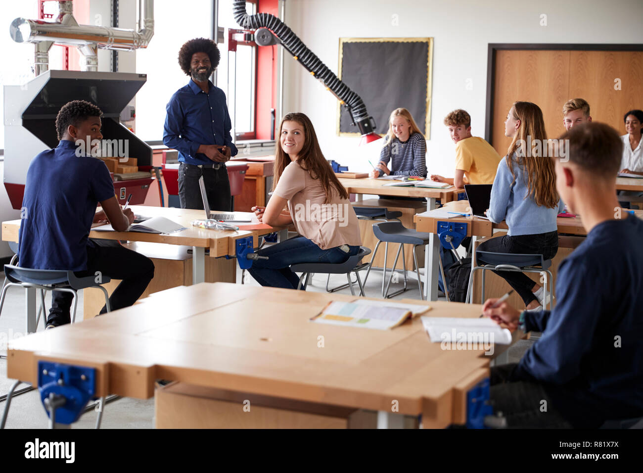 Classe d'élèves du secondaire assis à écouter les bancs de travail à l'enseignant dans la conception et la technologie Leçon Banque D'Images