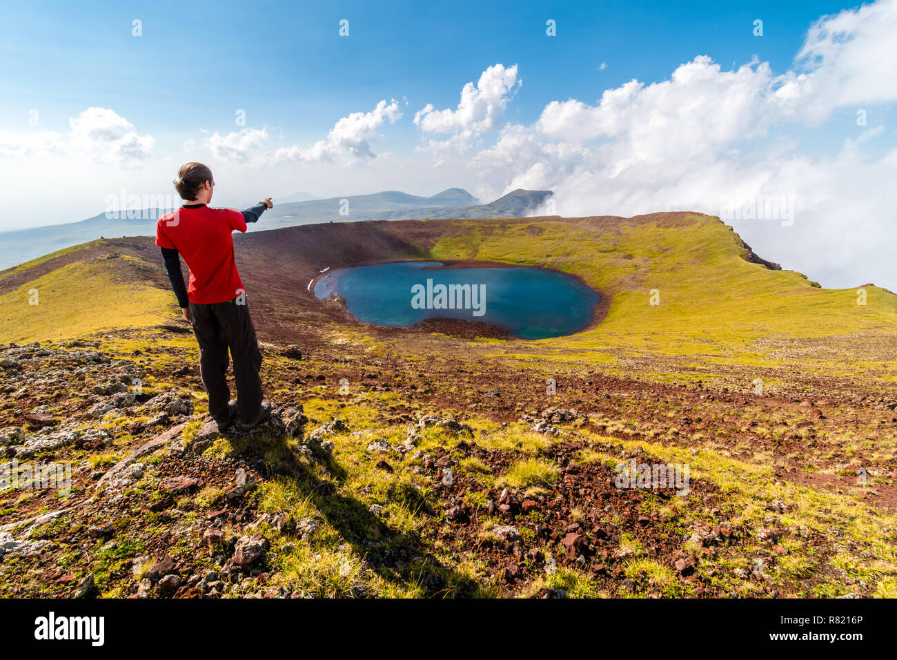 L'homme sur un sommet des Azhdahak regardant le lac du cratère du volcan, montagnes Geghama, Arménie Banque D'Images